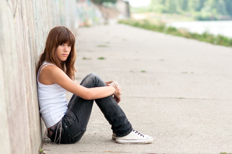 Cute sad teenage girl sitting