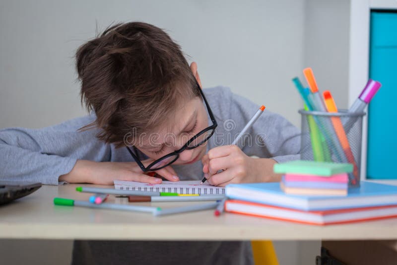 Cute School Kid in Glasses Studying at Home Writing Notes Sitting at Desk.  Schoolboy Writes Homework with His Left Hand Stock Image - Image of  learning, schoolkid: 214841313