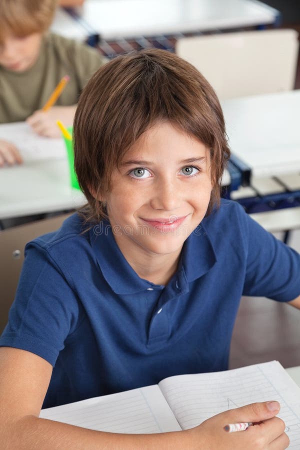 Cute Schoolboy Smiling In Classroom stock photography Cute Schoolboy Smiling In Classroom stock photography