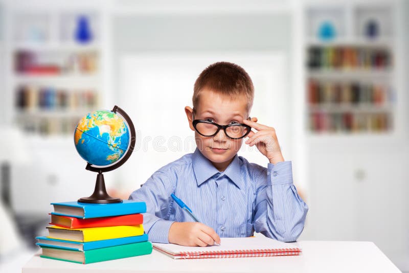 Cute schoolboy is writting homework royalty free stock images Cute schoolboy is writting homework royalty free stock images