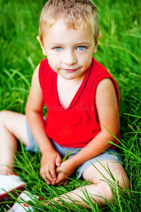 Cute serene kid on fresh green grass