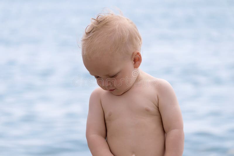 Cute shy one year toddler on the beach stock image