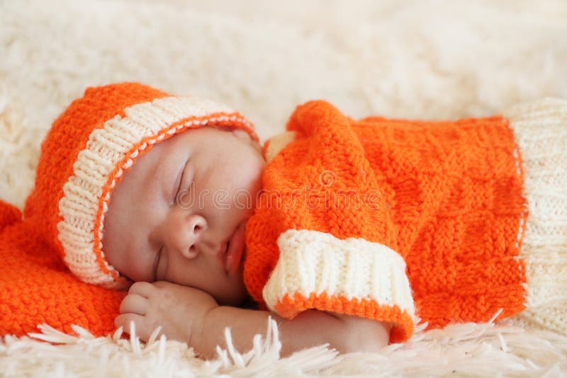 Cute sleeping newborn baby dressed in a knitted orange costume o royalty free stock image Cute sleeping newborn baby dressed in a knitted orange costume o royalty free stock image