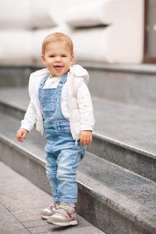 Cute Smiling Baby Girl 1-2 Year Old Wear Casual Denim Pants and White Top  in City Street Outdoors. Looking at Camera Stock Image - Image of outdoors,  playful: 242749701