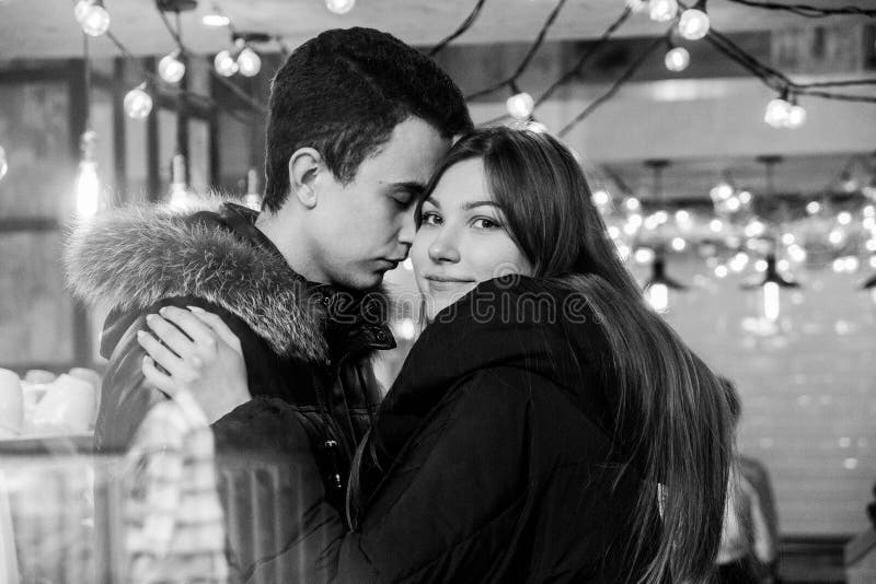 Cute Smiling Couple In Love Standing In A Cafe Hugging Each Other