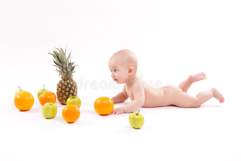 Cute smiling healthy child lies on a white background among frui