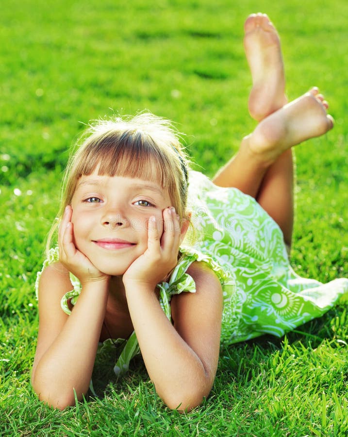 Cute Smiling Little Girl Lying on a Green Grass in the Park on a Stock ...