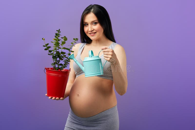 Smiling pregnant woman in headphones dancing in studio over purple  background. Stock Photo by ©ufabizphoto 265681264