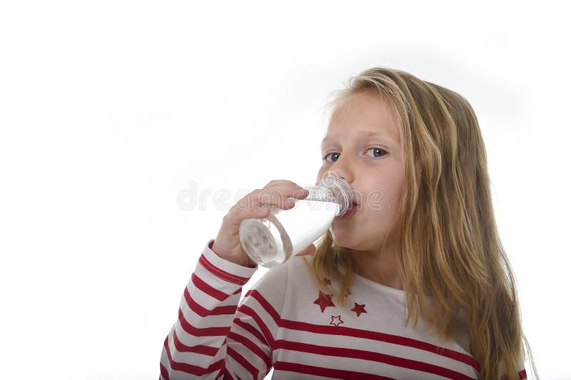 Cute sweet little girl with blue eyes and blond hair 7 years old holding bottle of water drinking