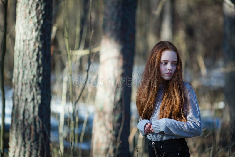 Teen Girl With Fiery Red Hair Posing In The Pine Park For A