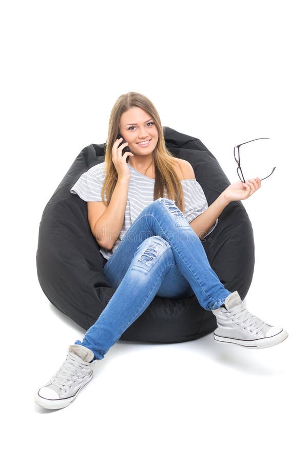 Cute teenage girl talking on the phone sitting on beanbag
