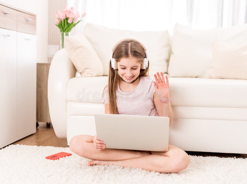 Cute teenager girl smiling at her laptop