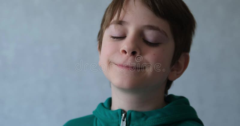 Cute teenager removes hair from the face. Portrait of a happy schoolboy boy at home