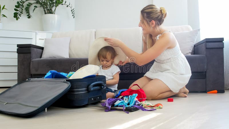 Cute toddler boy helping his mother packing thing for summer beach vacation royalty free stock images Cute toddler boy helping his mother packing thing for summer beach vacation royalty free stock images