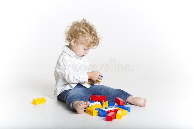 Cute toddler is building with legos