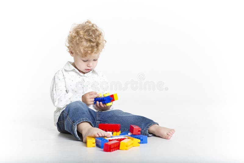 Cute toddler is building with legos