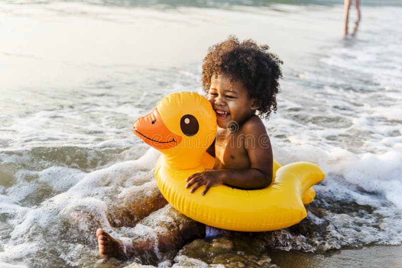 Cute toddler with duck tube on the beach