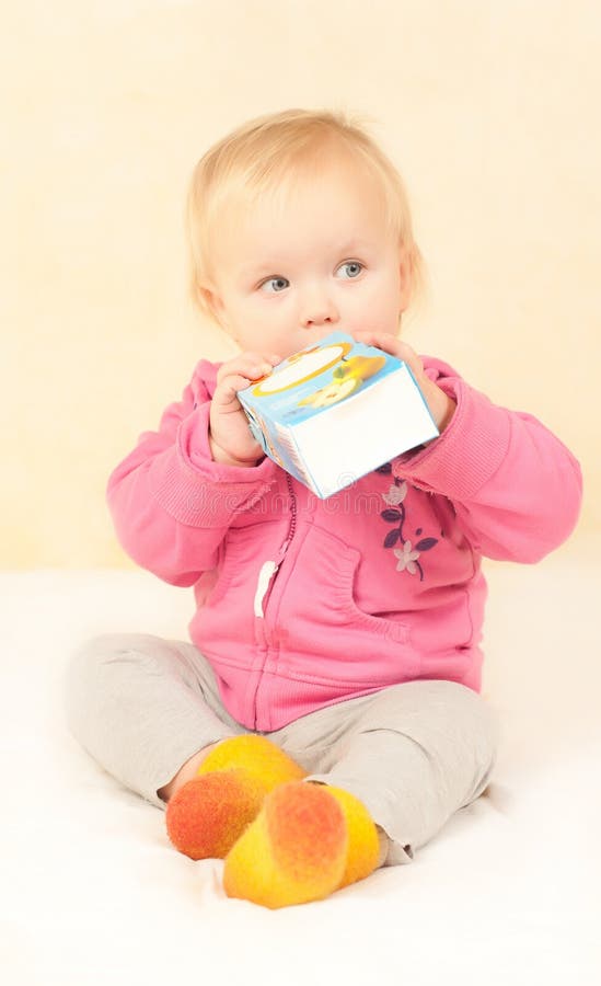 Cute toddler girl sit and drinking juice