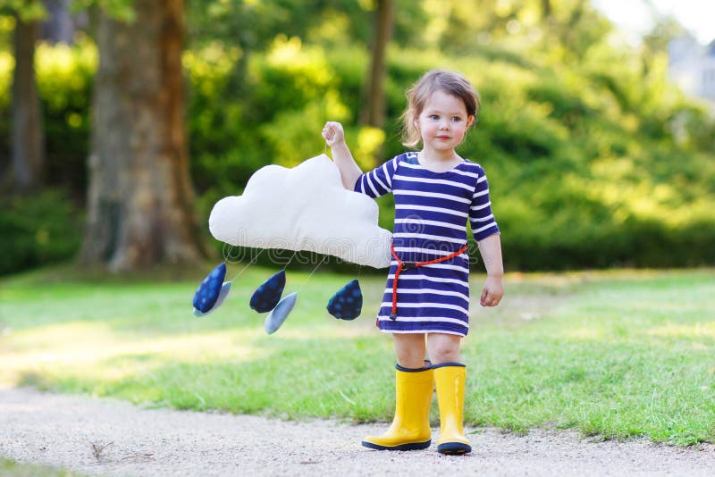 Cute toddler girl in yellow rubber boots