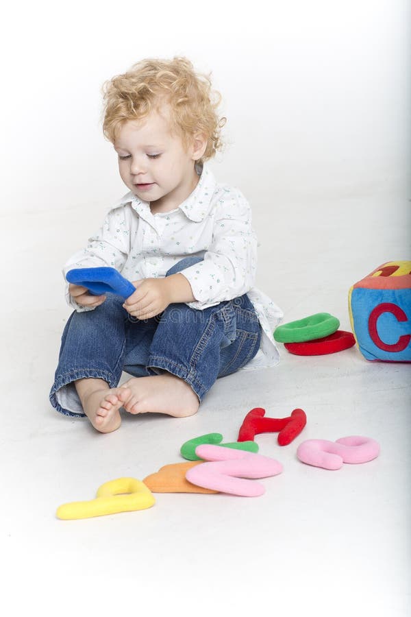 Cute toddler is playing with letters