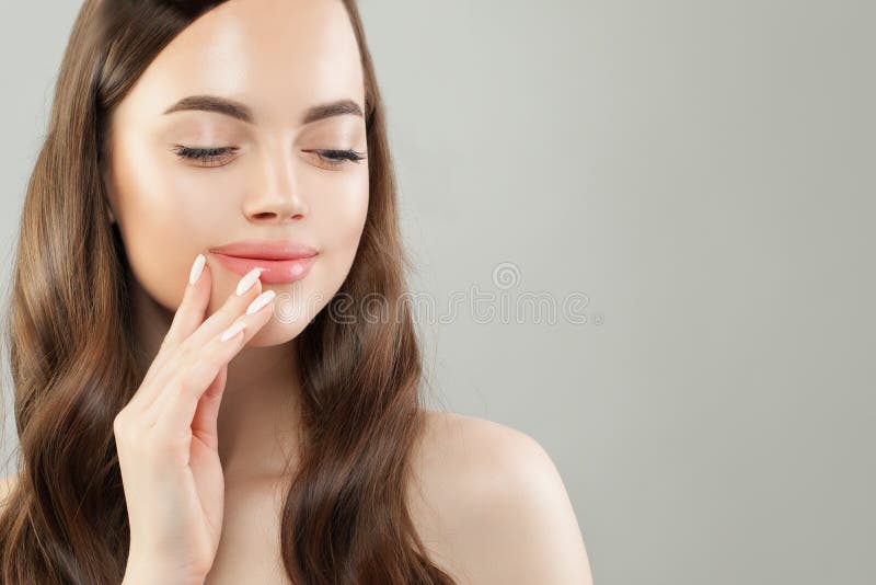 Cute woman with clear skin, long hair and manicured nails closeup portrait