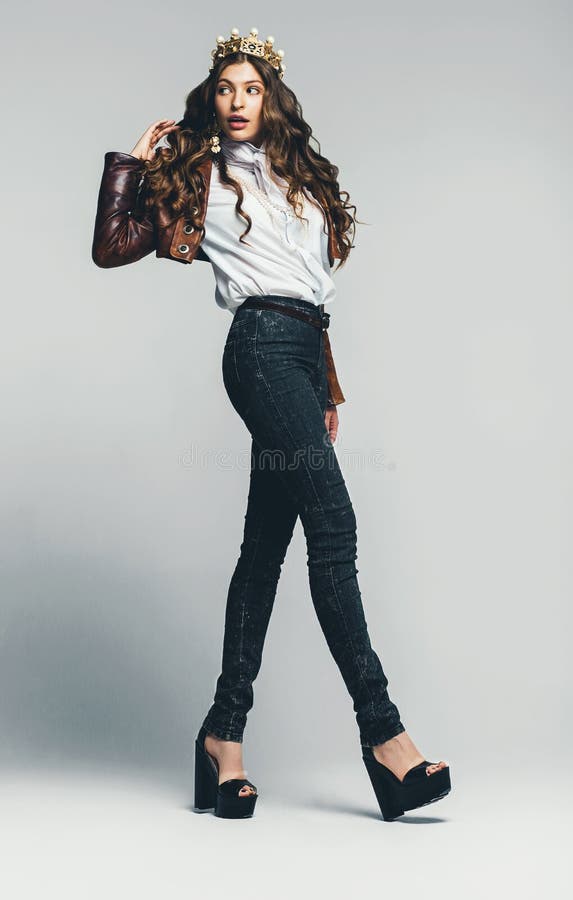 Cute woman in golden crown and jeans stock photos