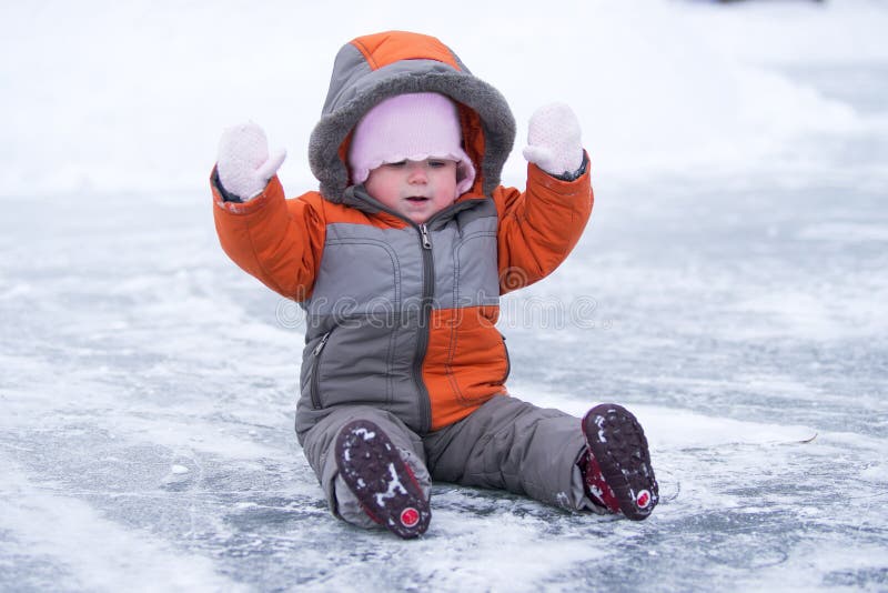 Cute wondered baby sit on lake s ice