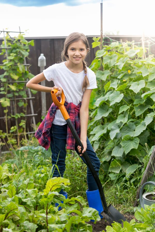 Cute 10 year old girl working at garden and digging soil stock image Cute 10 year old girl working at garden and digging soil stock image