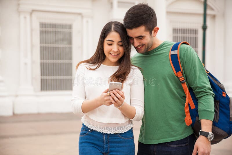 Cute young couple looking at a smartphone royalty free stock images Cute young couple looking at a smartphone royalty free stock images