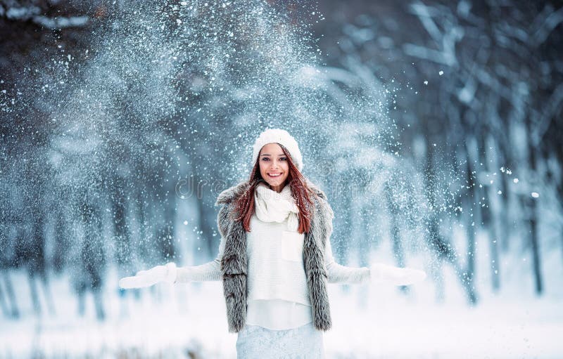 Cute young girl playing with snow