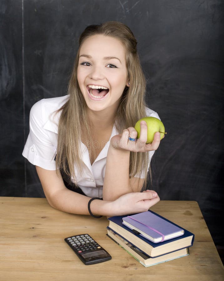 Cute young student near blackboard with copy book calculator pen, copy space