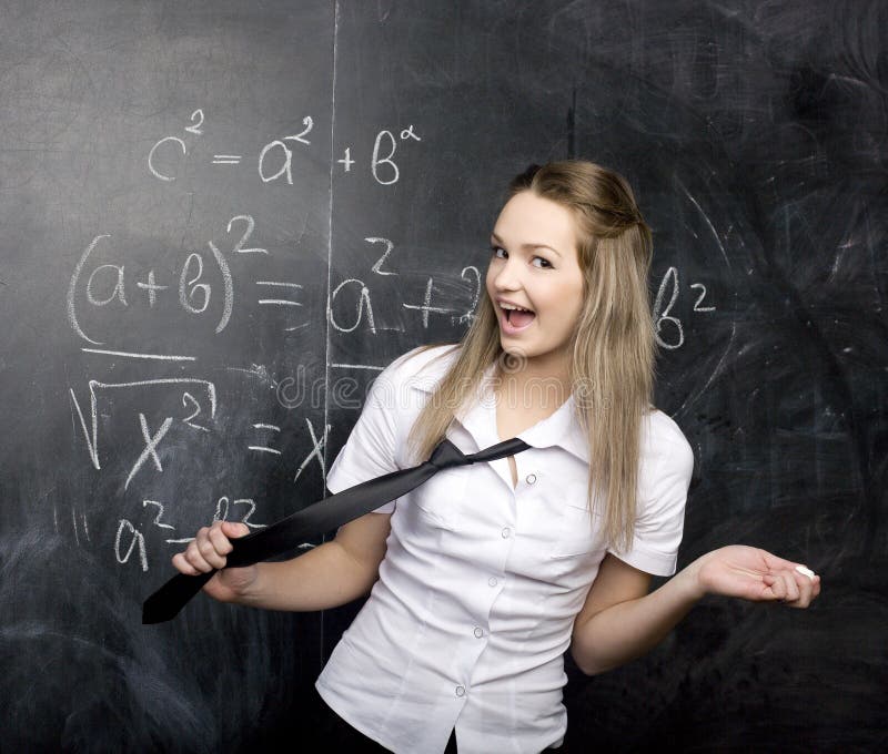 Cute young student near blackboard with copy book calculator pen, copy space