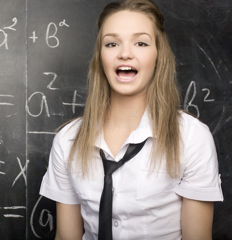 Cute young student near blackboard with copy book calculator pen, copy space