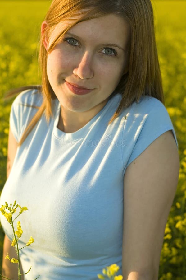 Cute woman smiling in a canola field. Cute woman smiling in a canola field.