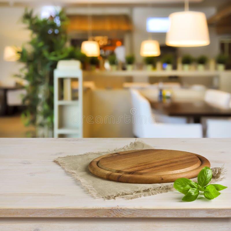 Cutting board on table over blurred restaurant interior background royalty free stock images Cutting board on table over blurred restaurant interior background royalty free stock images
