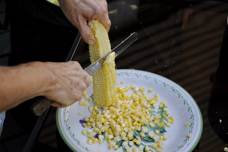 Cutting corn of the cob stock photo. Image of eating 125607392