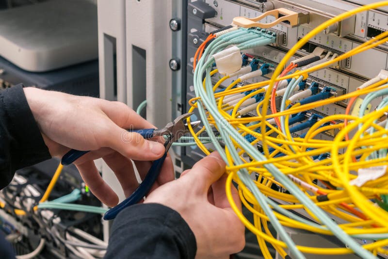 Cutting fiber in the server room. Cable cutters in the hands of an internet connection installer. The specialist removes