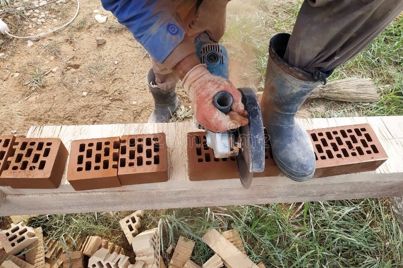 Cutting Bricks With An Angle Grinder In A Rural Yard Stock Photo