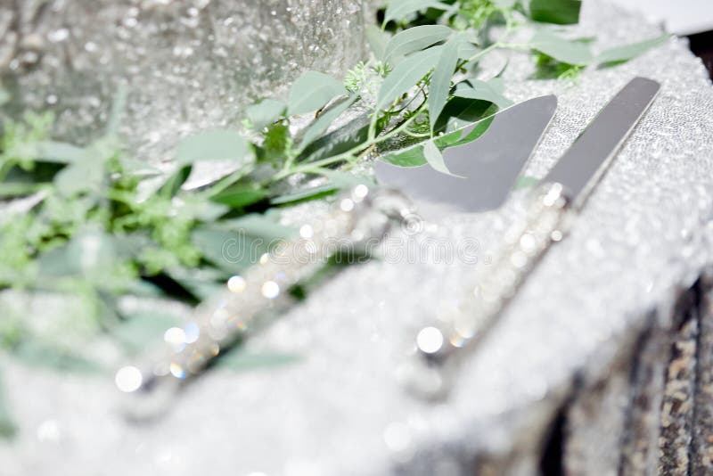 Cutting Knife and Spatula for a Wedding Cake on a Silver Tablecloth