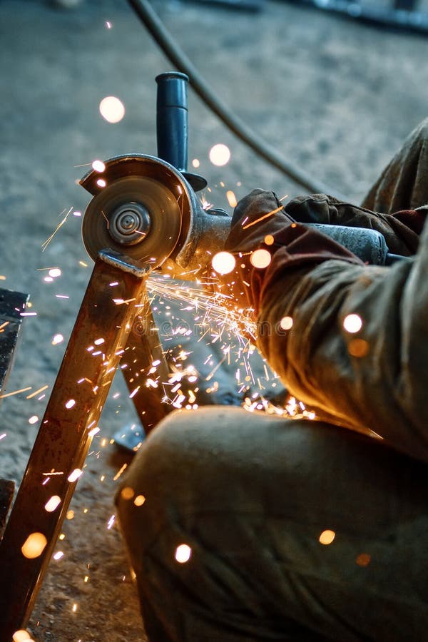 Cutting a Metal Beam Using an Angle Grinder. a Lot of Sparks Fly Out
