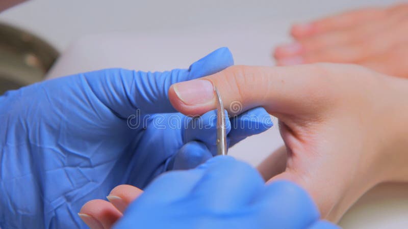 Cutícula clara do manicuro com as tesouras profissionais para o tratamento de mãos fotografia de stock royalty free Cutícula clara do manicuro com as tesouras profissionais para o tratamento de mãos fotografia de stock royalty free
