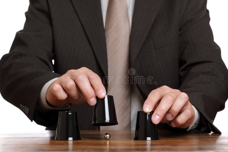 Businessman performing shell game scam with cups concept for corporate theft, chance, choice or making decisions. Businessman performing shell game scam with cups concept for corporate theft, chance, choice or making decisions