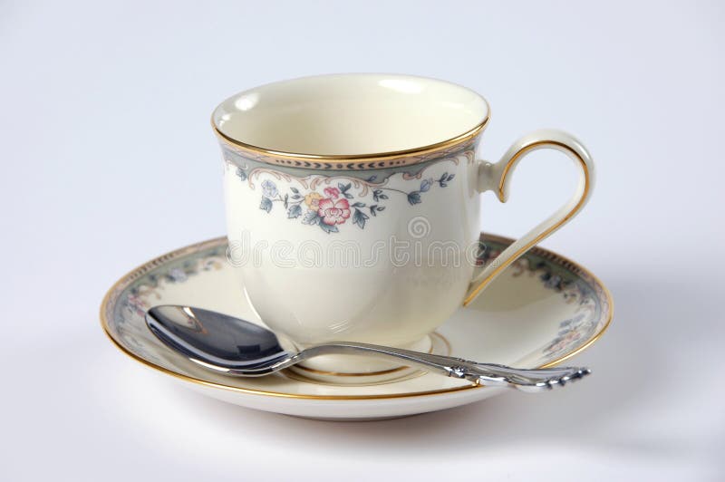 Fine China cup with saucer and spoon over a white background. Fine China cup with saucer and spoon over a white background.