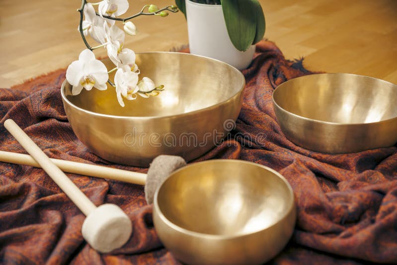 An image of some singing bowls and a white orchid. An image of some singing bowls and a white orchid
