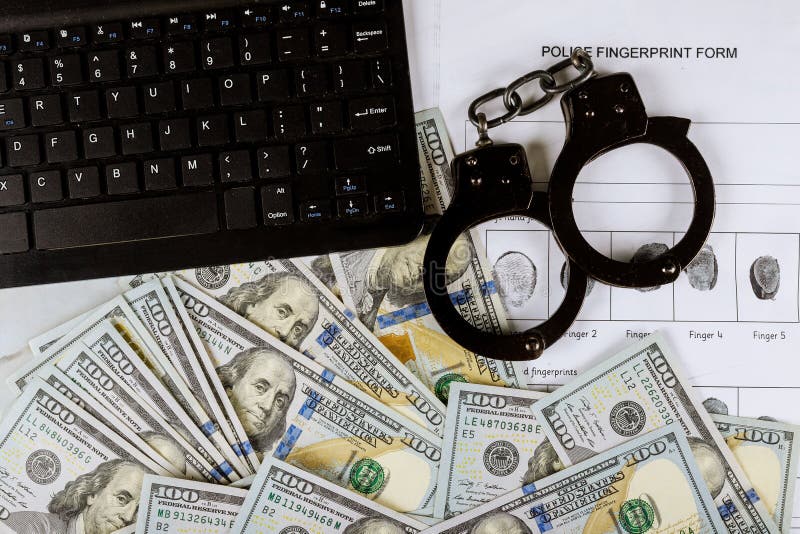 Cyberprzestępczość finansowa z kajdankami na kasę $1000 rachunków za odciski palców na stronie zbrodni obraz stock Cyberprzestępczość finansowa z kajdankami na kasę $1000 rachunków za odciski palców na stronie zbrodni obraz stock