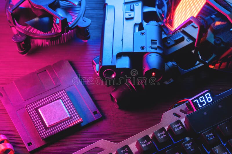 Cyberpunk concept background. Floppy disk, guns, computer keyboard, cpu chip and glasses on the black table background in neon lights