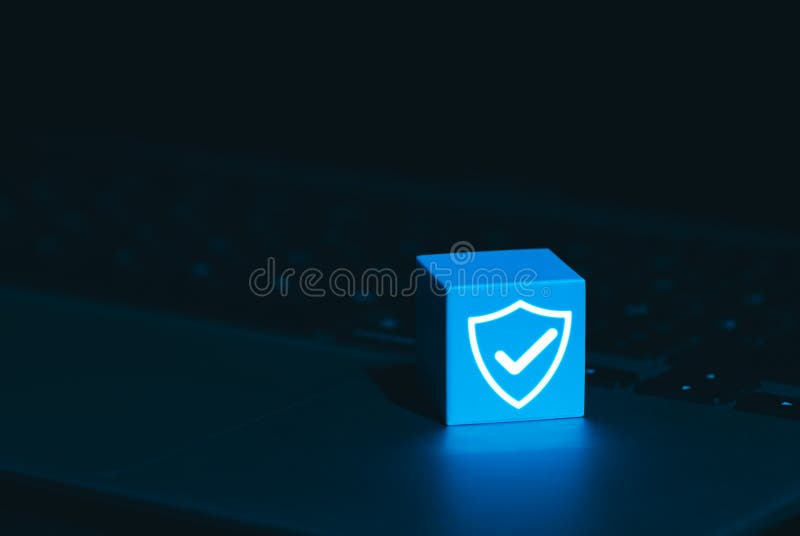 Cybersecurity and Data Protection Symbol Concept. A glowing blue cube with shield and checkmark icon on laptop keyboard, symbolizing cyber security, digital protection, trusted data security systems. Shield artificial intelligence stock images, royalty-free photos and pictures