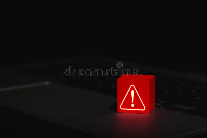 Cybersecurity Warning Alert Symbol. Glowing red warning triangle block with exclamation mark placed on laptop, symbolizing system royalty free stock images