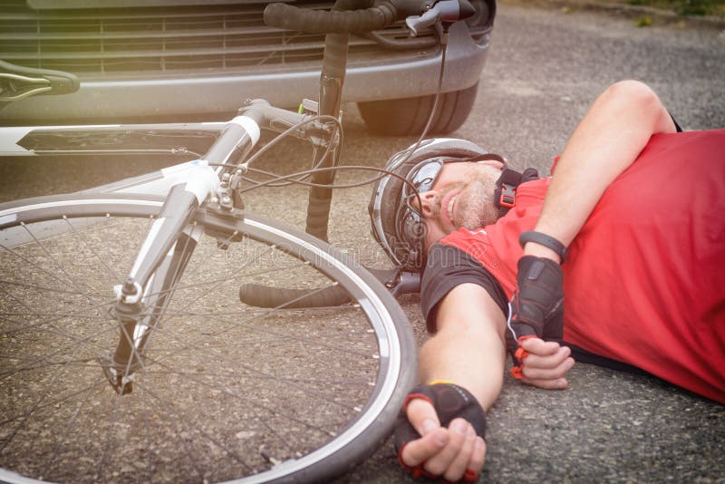 Cyclist lying on the road after hitting by a car