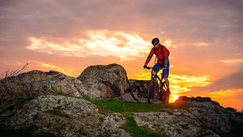 Cyclist Riding Mountain Bike on the Spring Rocky Trail at Beautiful Sunset. Extreme Sports and Adventure Concept. royalty free stock photos Cyclist Riding Mountain Bike on the Spring Rocky Trail at Beautiful Sunset. Extreme Sports and Adventure Concept. royalty free stock photos